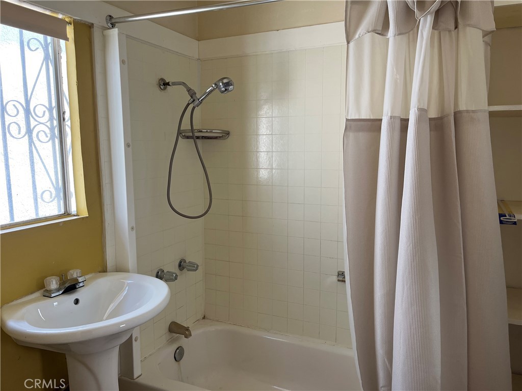 7763 Compton Avenue Los Angeles, CA 90001 - Photo 15 of 20 a bathroom with a sink a glass door and shower