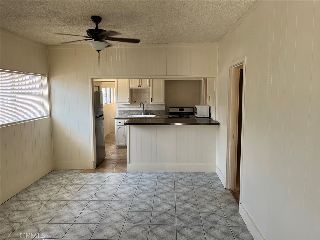 7763 Compton Avenue Los Angeles, CA 90001 - Photo 9 of 20 a kitchen with stainless steel appliances a refrigerator and a stove top oven