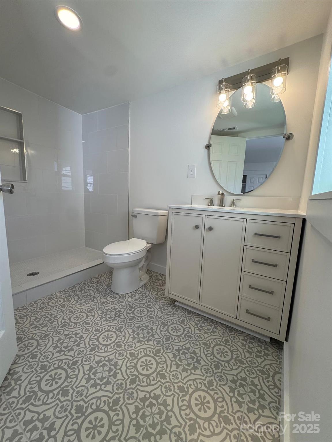 1018 Union Street Maiden, NC 28650 - Photo 25 of 46 a bathroom with a toilet a sink and mirror