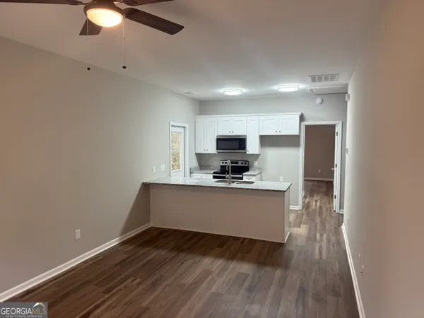 a kitchen with a refrigerator and a stove top oven
