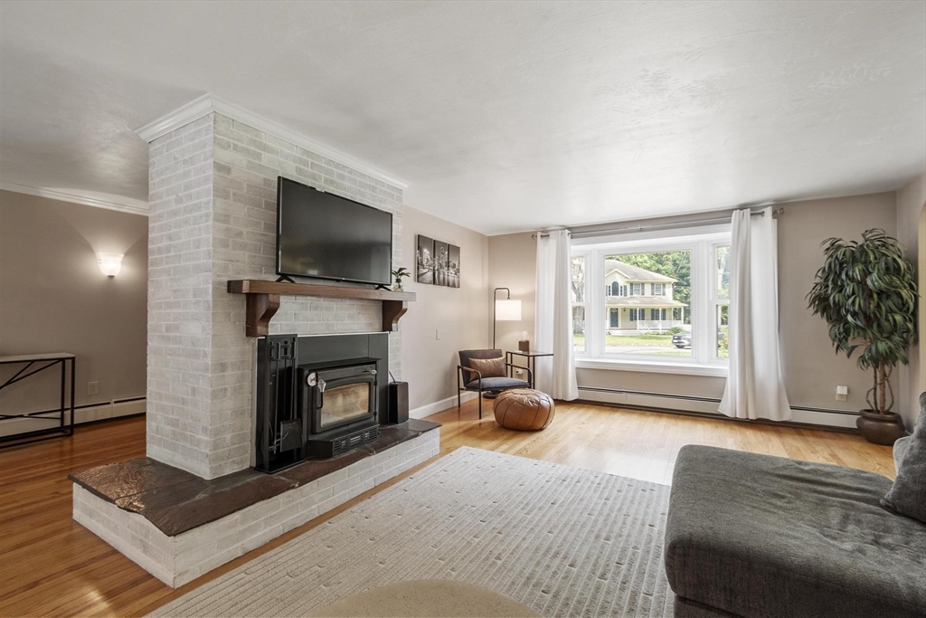 167 Gates Pond Road Berlin, MA 01503 - Photo 8 of 32 a living room with furniture a flat screen tv and a fireplace
