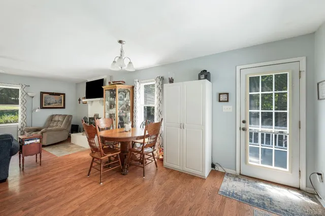 a kitchen with a wooden floor and a view of living room