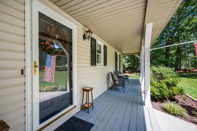 a view of backyard with deck and outdoor seating