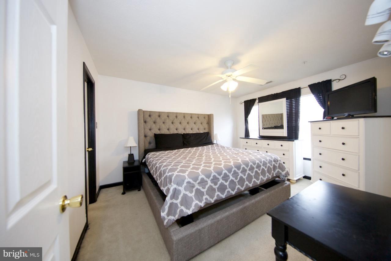 9701 Selfridge Road Baltimore, MD 21220 - Photo 17 of 29 a bedroom with a large bed and a flat tv screen on dresser