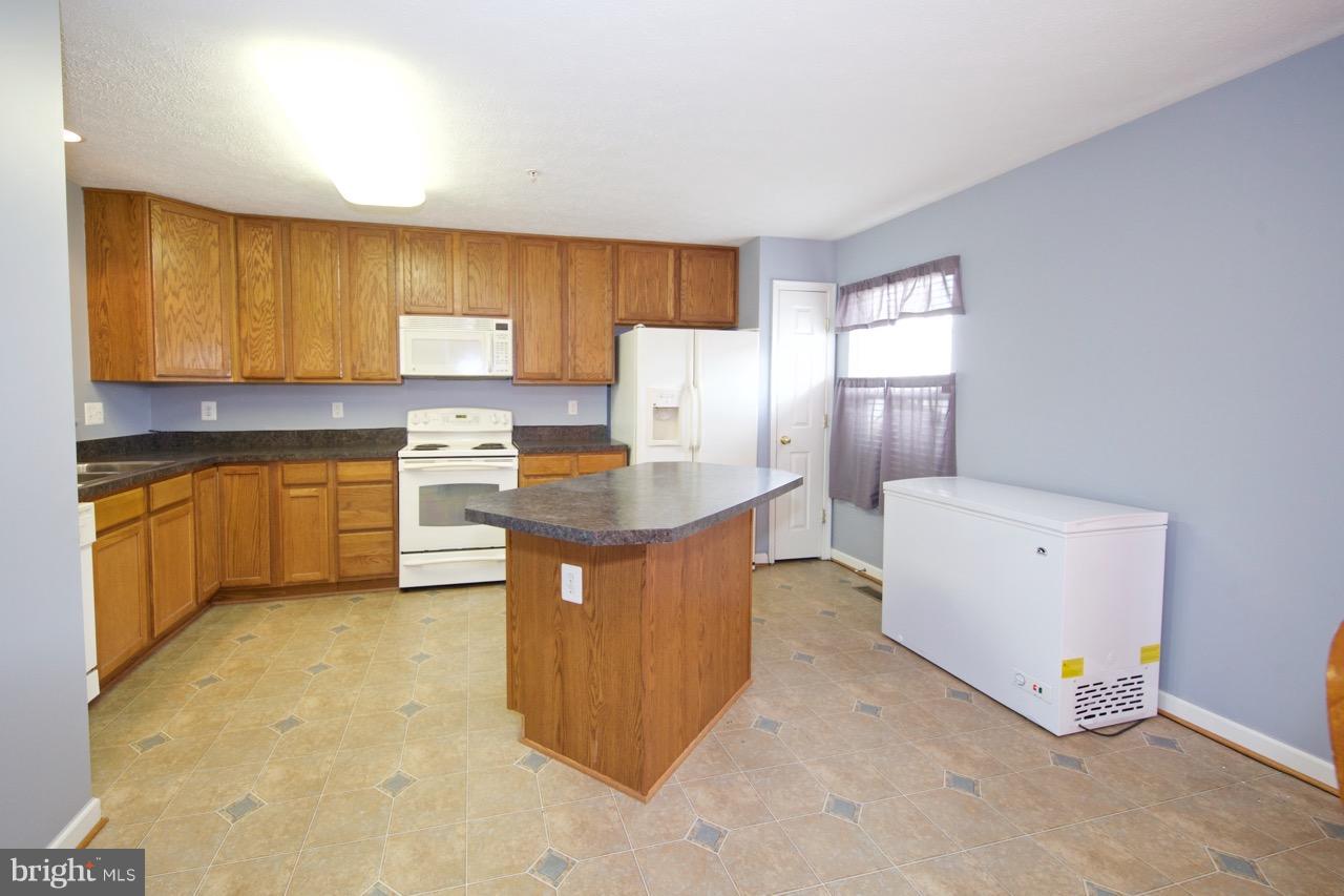 9701 Selfridge Road Baltimore, MD 21220 - Photo 5 of 29 a open kitchen with a sink stove and cabinets