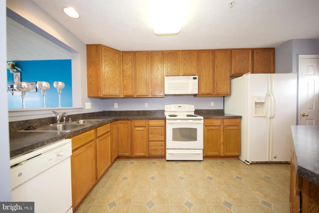 9701 Selfridge Road Baltimore, MD 21220 - Photo 7 of 29 a kitchen with white cabinets and white appliances