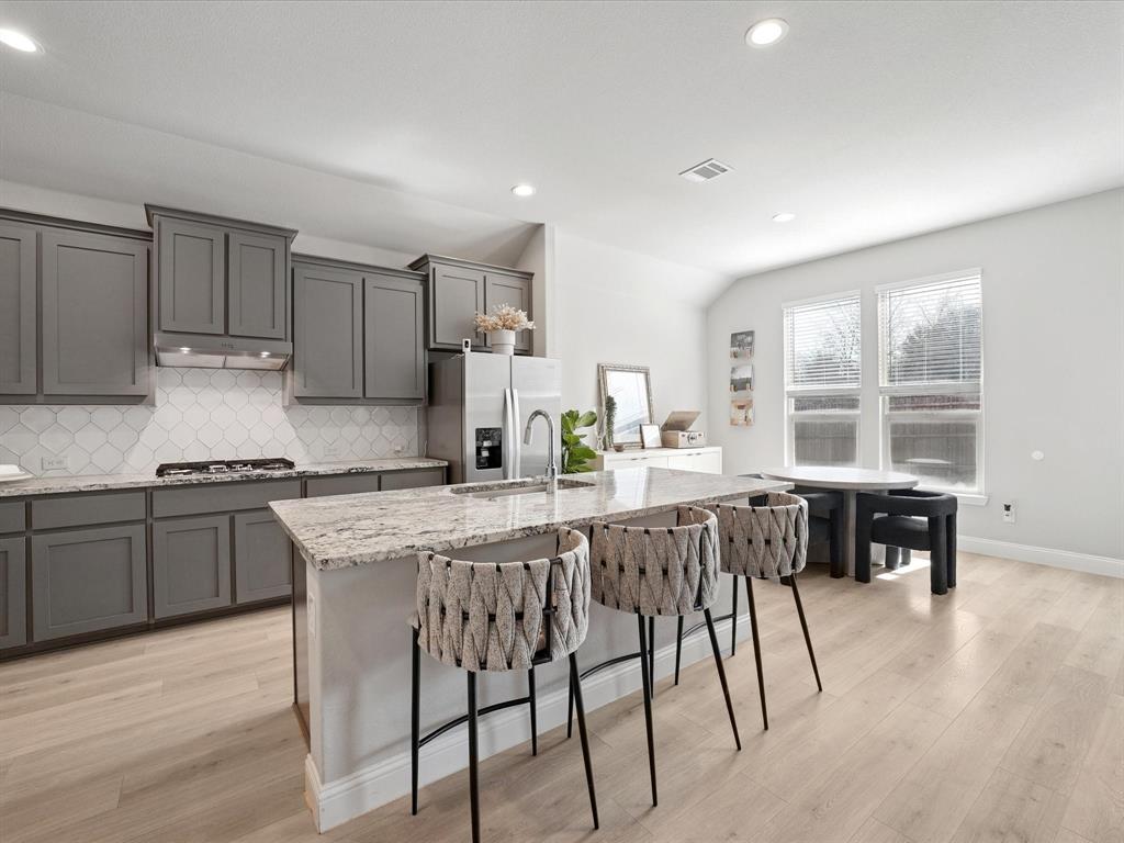 3711 Walnut Rdg Drive Grand Prairie, TX 76065 - Photo 6 of 24 a kitchen with stainless steel appliances granite countertop wooden floor and white cabinets