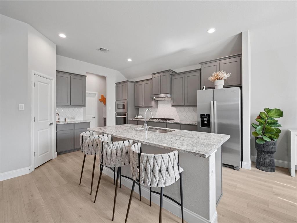 3711 Walnut Rdg Drive Grand Prairie, TX 76065 - Photo 7 of 24 a kitchen with granite countertop white cabinets and stainless steel appliances