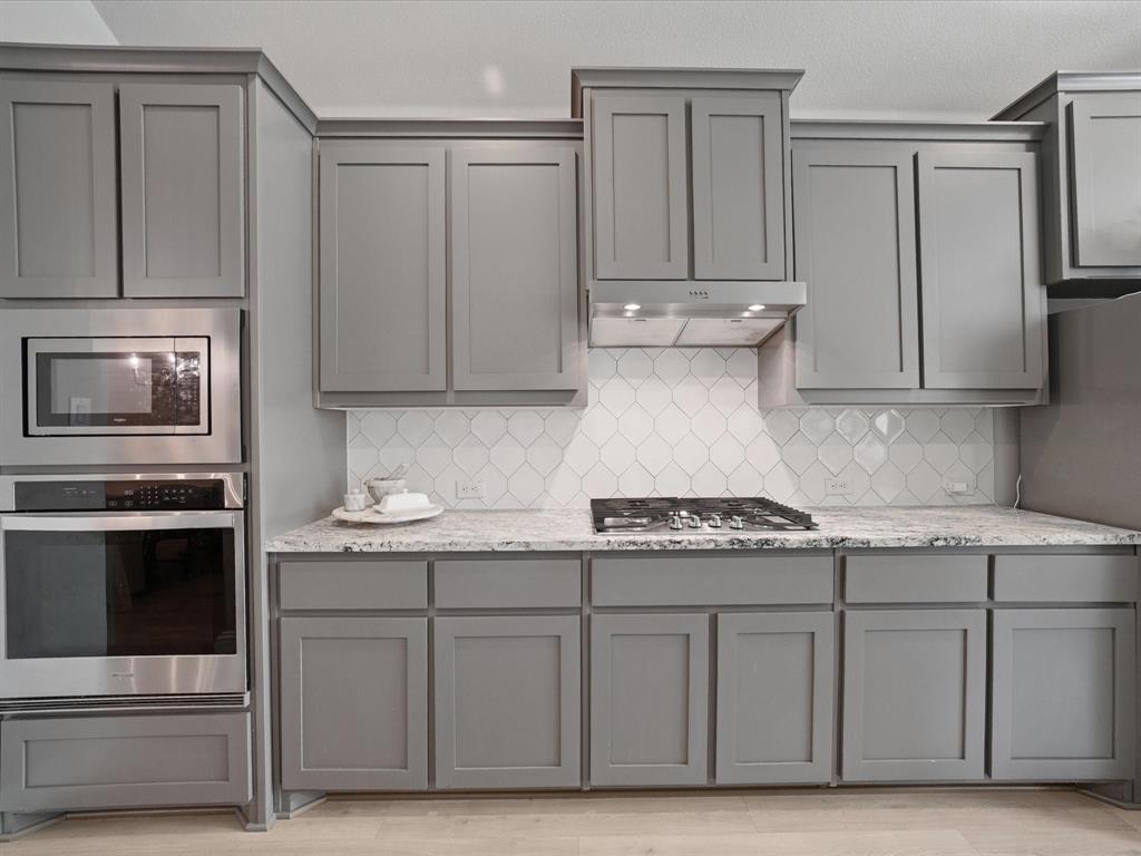 3711 Walnut Rdg Drive Grand Prairie, TX 76065 - Photo 8 of 24 a kitchen with stainless steel appliances granite countertop a stove a sink and a microwave