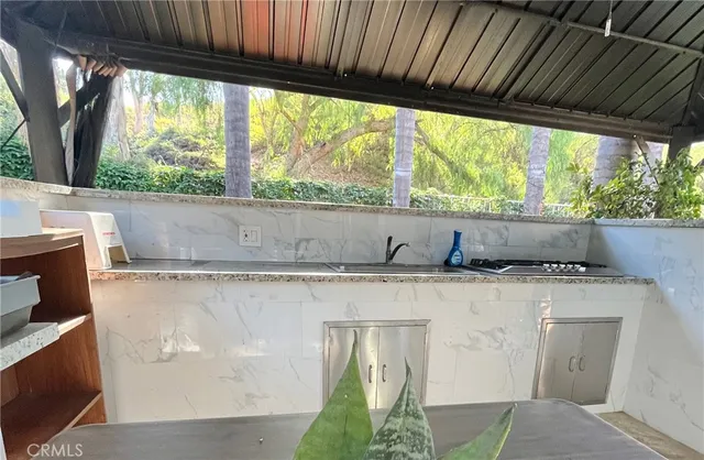 a kitchen with a large window cabinets and outdoor space