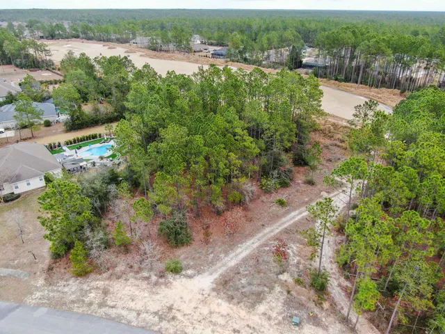 an aerial view of a houses with a yard and lake view