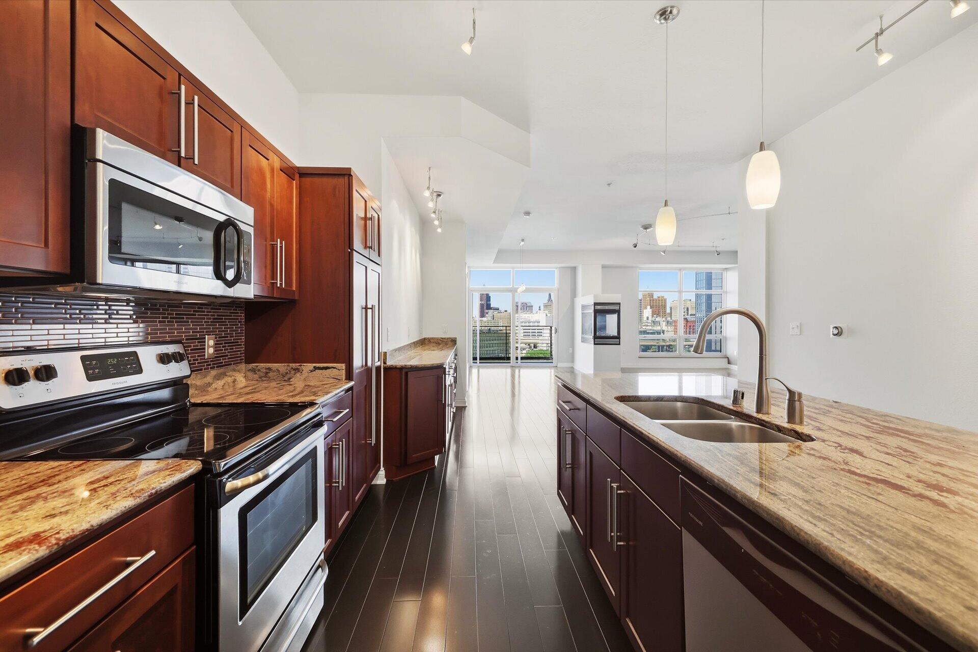 106 West Seeboth Street, Unit 920 Milwaukee, WI 53204 - Photo 6 of 51 Stainless Steel appliances with granite counters and kitchen island and buffet bar