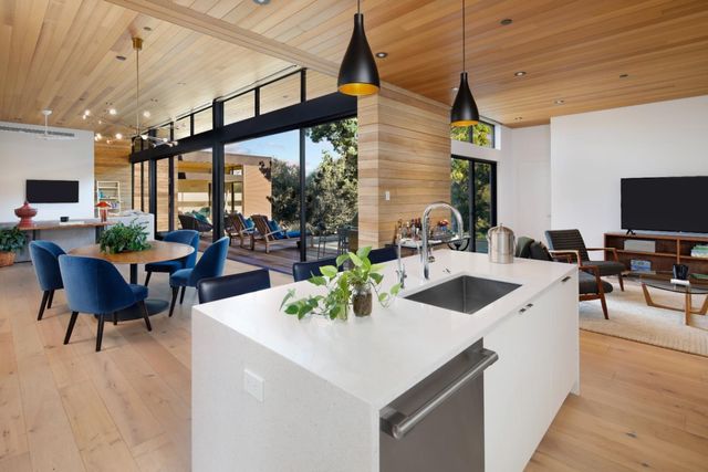 a kitchen with a sink a counter and chairs