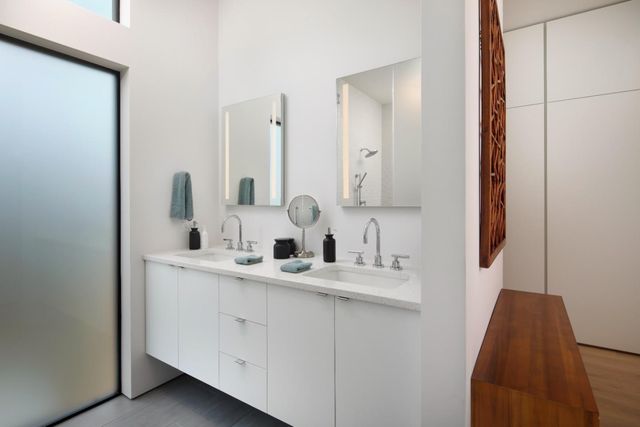 a bathroom with double vanity and a mirror