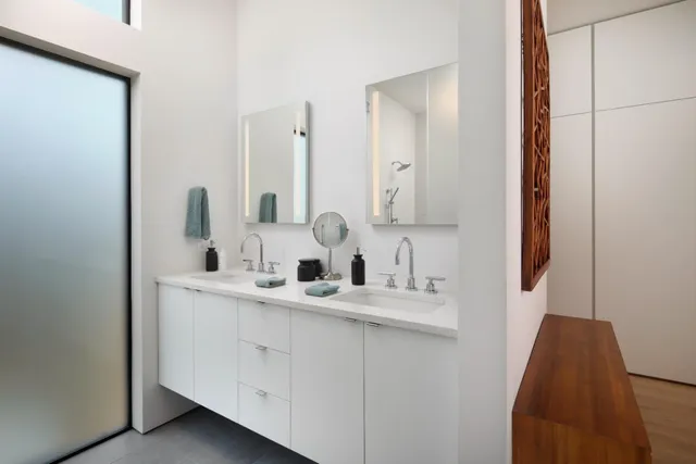 a bathroom with double vanity and a mirror