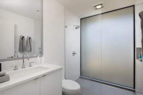 a bathroom with a sink a toilet and shower
