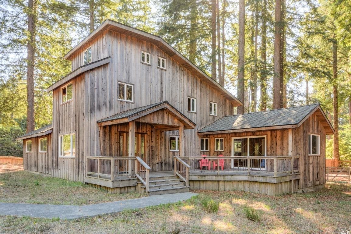 46450 Fish Rock Road Gualala, CA 95445 - Photo 1 of 1 a view of a white house with large windows and a small yard