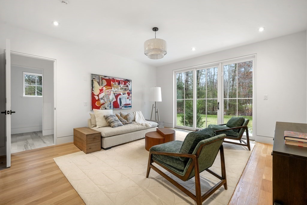 5 Radcliffe Road Weston, MA 02493 - Photo 23 of 41 a living room with furniture a flat screen tv and a floor to ceiling window