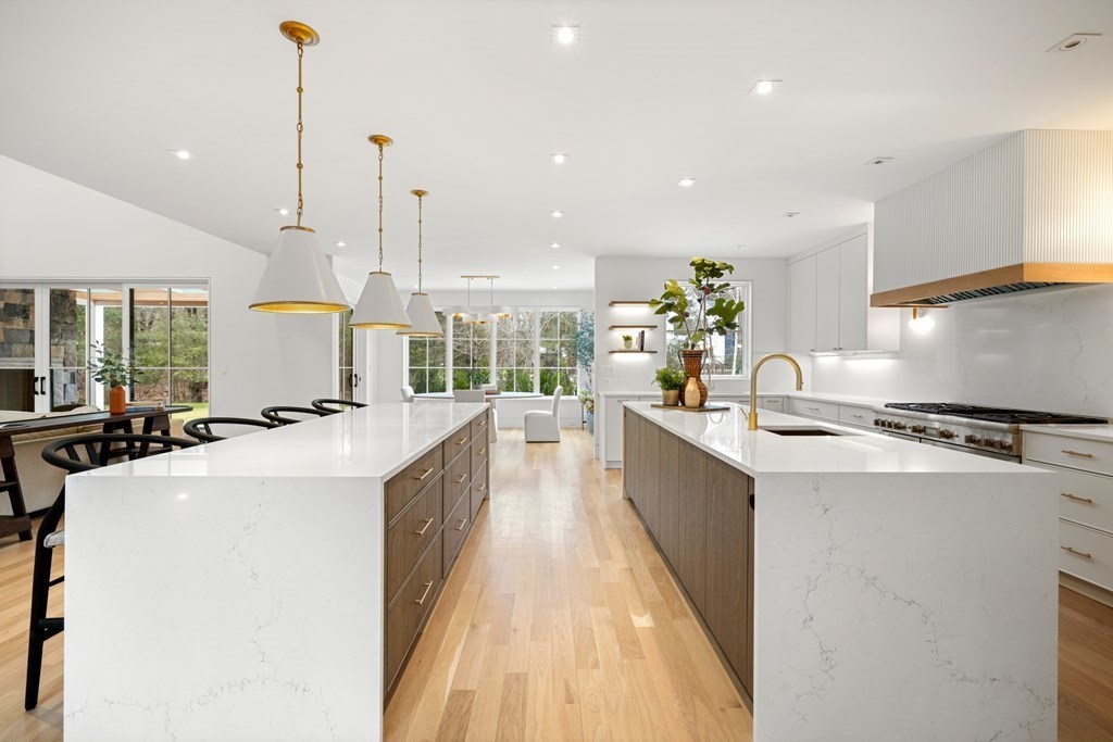 5 Radcliffe Road Weston, MA 02493 - Photo 6 of 41 a large kitchen with stainless steel appliances a sink a counter top space a large window and a chandelier