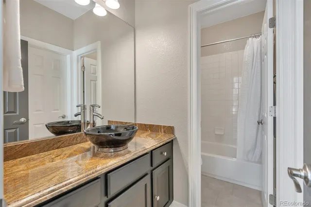 a bathroom with a granite countertop sink and a mirror
