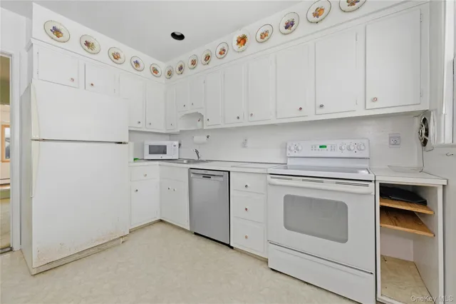 a kitchen with cabinets appliances a sink and a refrigerator
