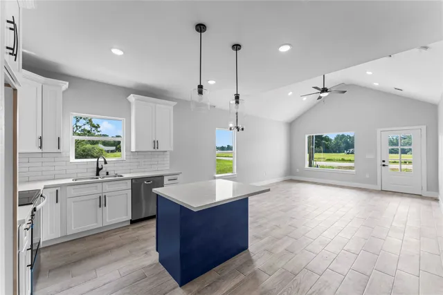 a large kitchen with kitchen island a sink stainless steel appliances and a center island