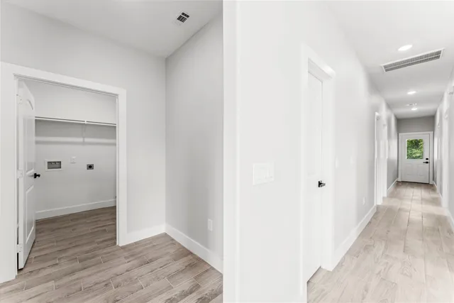 a view of a hallway with wooden floor