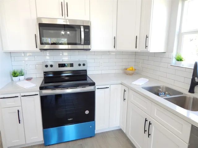 a kitchen with cabinets stainless steel appliances and a sink