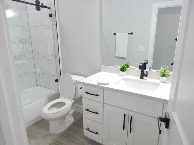 a bathroom with a sink toilet vanity and shower