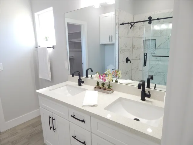 a bathroom with a sink vanity and shower