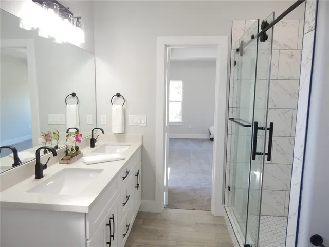 a bathroom with a double vanity sink a mirror a shower and vanity
