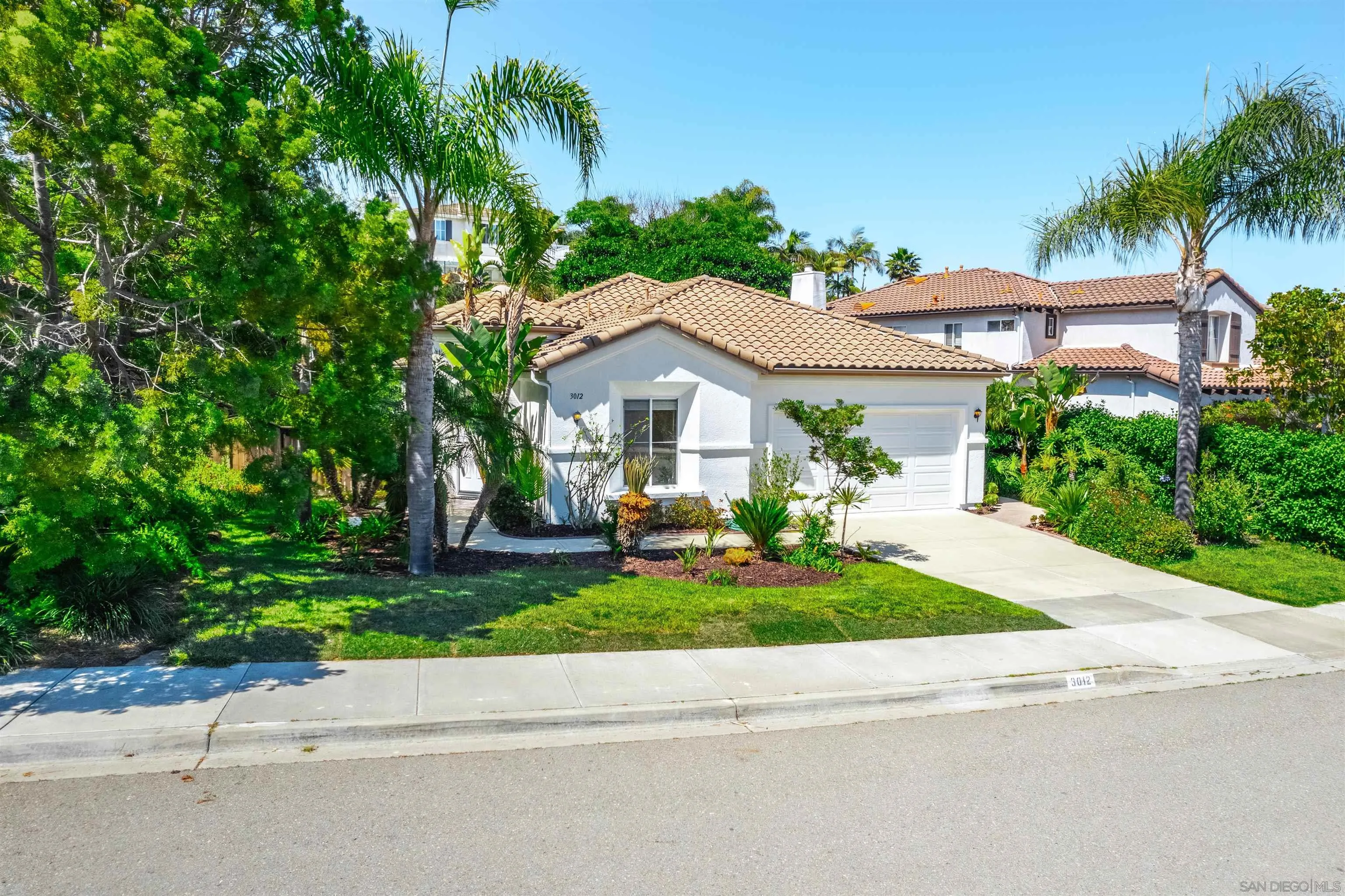 3012 Avenida Ciruela Carlsbad, CA 92009 - Photo 4 of 40 a front view of a house with a garden and trees