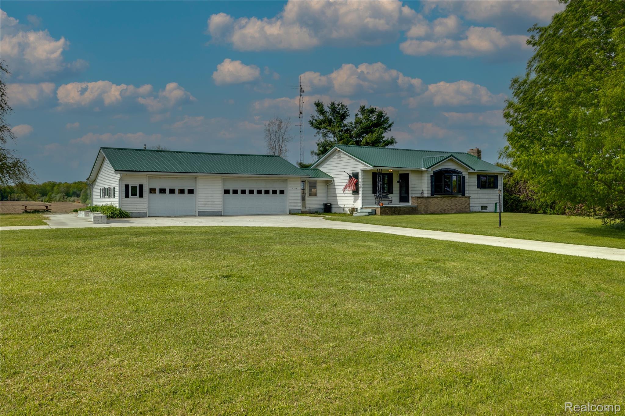 6373 Norman Road Jeddo, MI 48032 - Photo 16 of 32 View of front of home with a front lawn, driveway, a metal roof, a garage, and a chimney