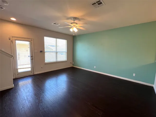 a view of a livingroom with a ceiling fan and wooden floor