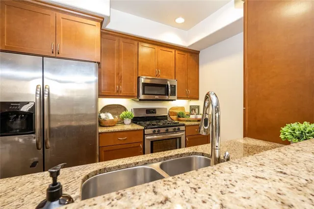 a kitchen with granite countertop a refrigerator and a sink