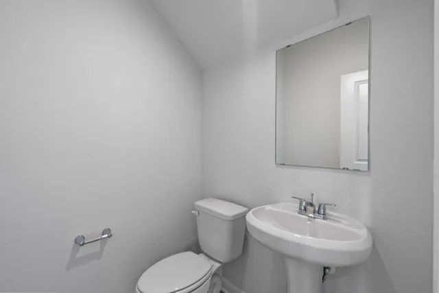 a bathroom with a sink a toilet and mirror