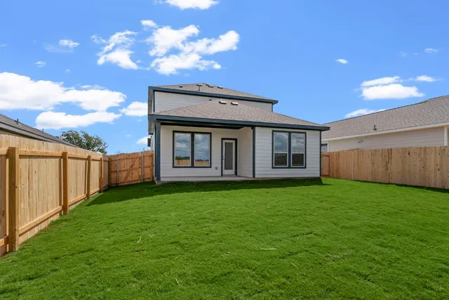 a view of a backyard with plants and large trees