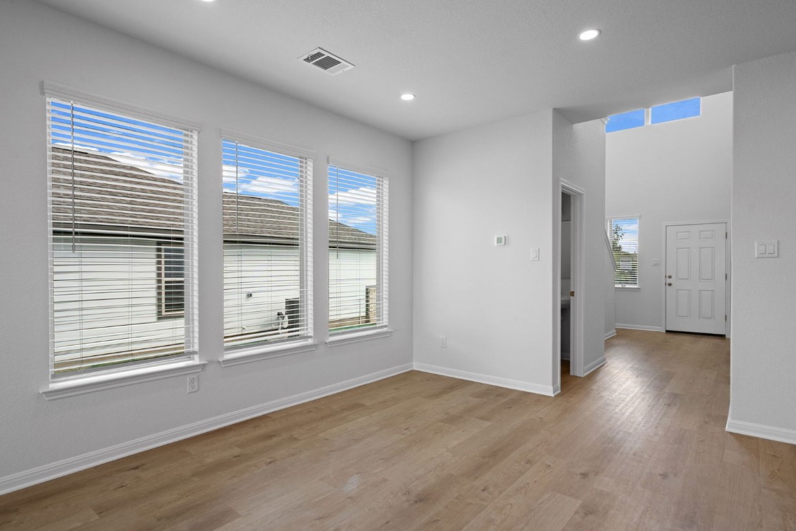 145 Hatari Trail Jarrell, TX 76537 - Photo 3 of 37 an empty room with wooden floor and windows