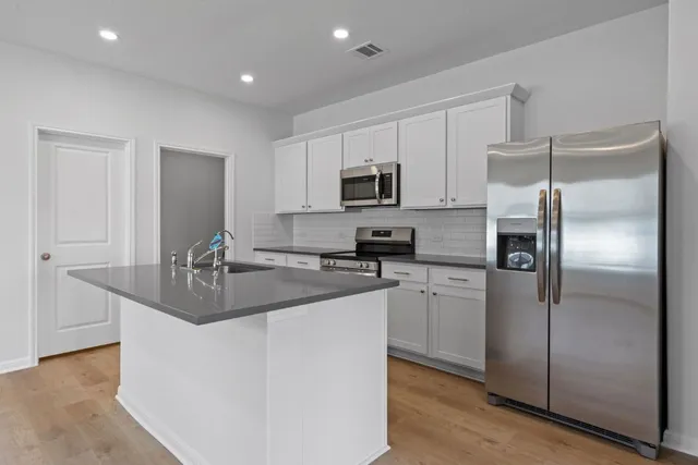 a kitchen with kitchen island a sink stove and refrigerator
