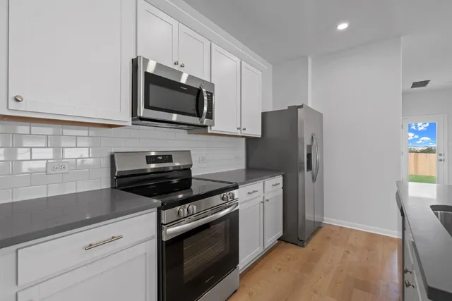 a kitchen with stainless steel appliances a stove microwave and refrigerator