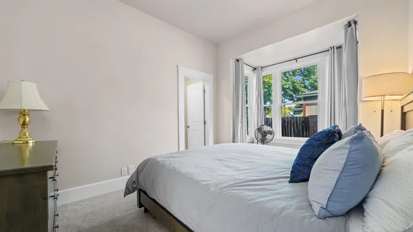 a bedroom with a bed a lamps and a dresser