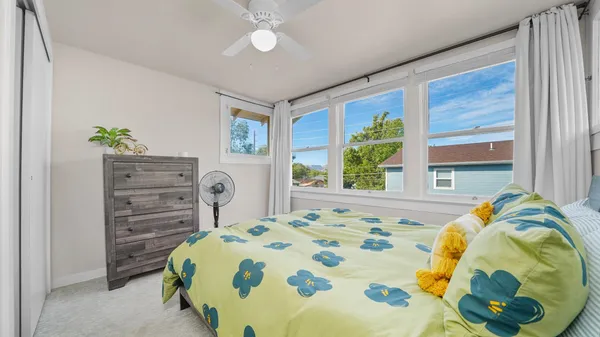 a bedroom with a bed a dresser and painting on the wall