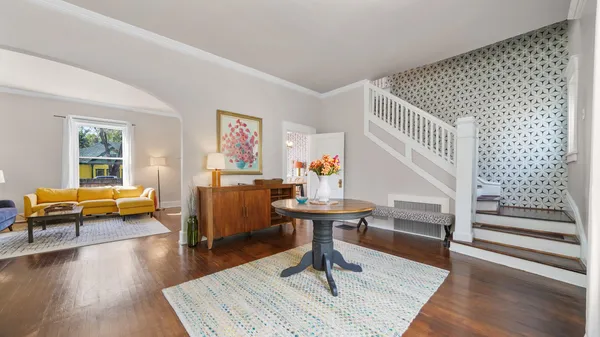 a living room with furniture and a wooden floor