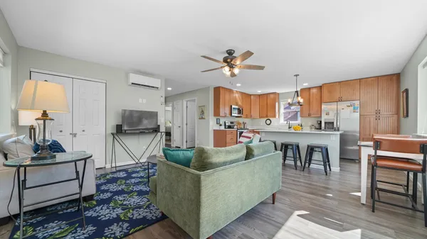 a living room with furniture a table and kitchen view