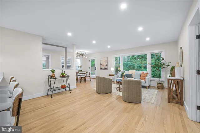 a living room with furniture a large window and wooden floor