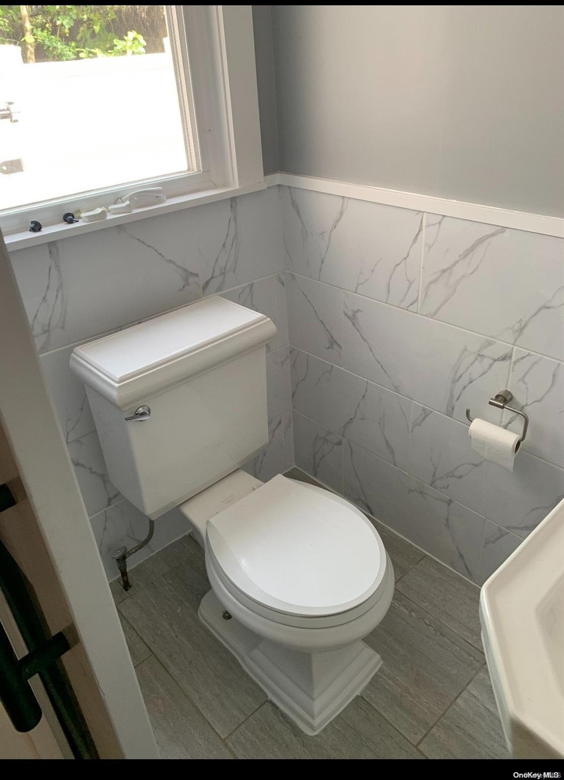 76-22 57th Road Queens, NY 11379 - Photo 7 of 9 a white toilet sitting next to a window