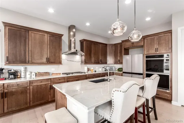 a kitchen with kitchen island granite countertop a sink a center island stainless steel appliances and cabinets