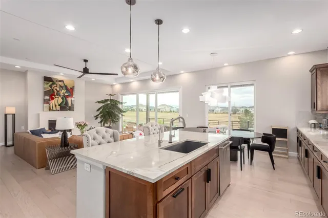 a kitchen with stainless steel appliances granite countertop a stove and a view of living room