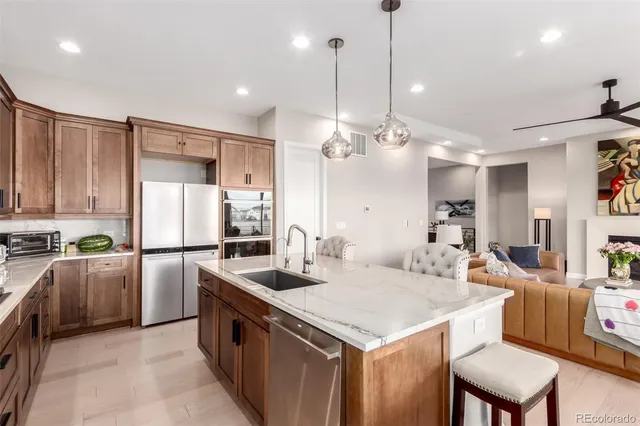 a kitchen with a refrigerator a sink and chairs