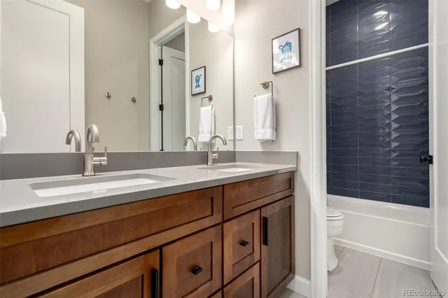 a bathroom with a granite countertop sink a toilet and bathtub